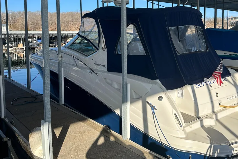 Slide: The Image of 2008 Sea Ray 340 Sundancer docked, featuring a blue canopy and sleek white hull. - 2