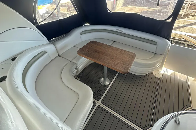 Slide: The Image of 2008 Sea Ray 340 Sundancer interior with curved seating and wooden table. - 8