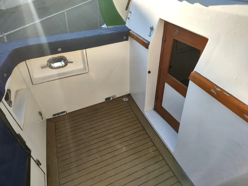 Slide: The Image of 1986 Nova 48 Cockpit Motor Yacht, featuring a wooden deck and door, with blue trim accents. - 16