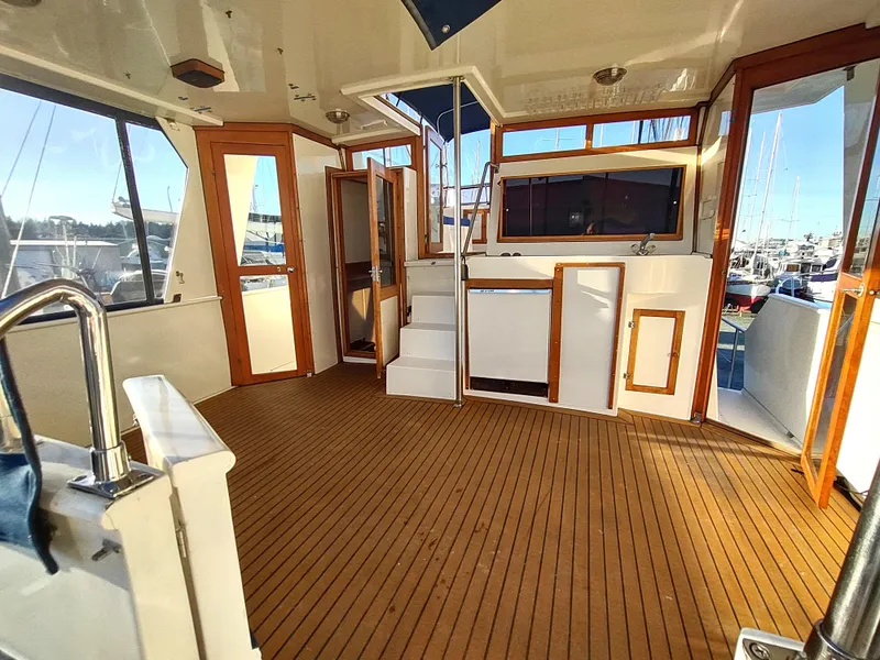Slide: The Image of 1986 Nova 48 Cockpit Motor Yacht interior with wooden flooring and open doors. - 18