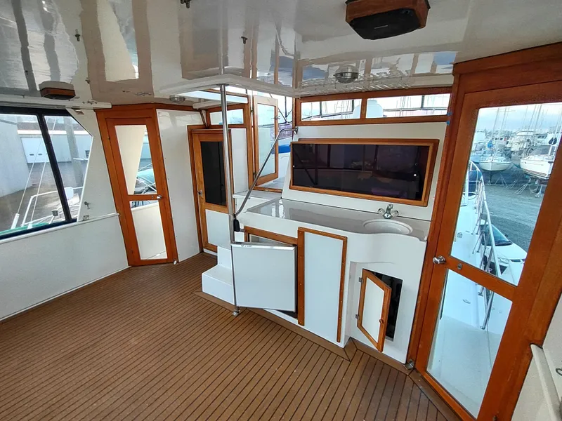 Slide: The Image of 1986 Nova 48 Cockpit Motor Yacht interior with wood accents and spacious layout. - 19