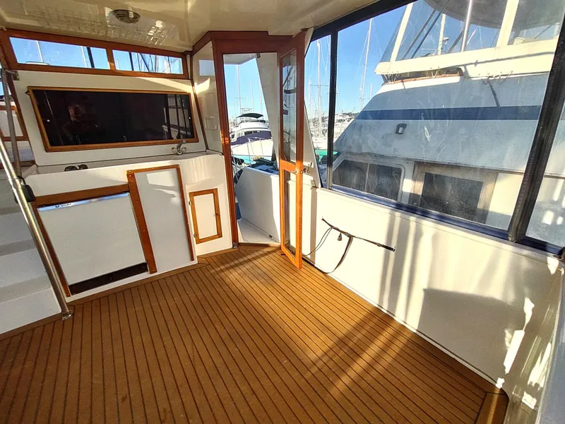 Slide: The Image of 1986 Nova 48 Cockpit Motor Yacht interior with wooden flooring and large windows. - 21