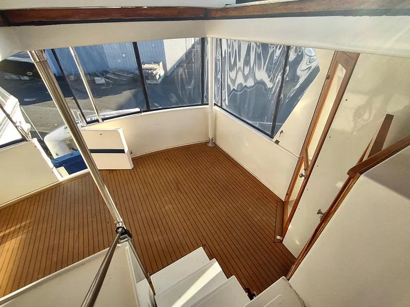 Slide: The Image of 1986 Nova 48 Cockpit Motor Yacht interior with wooden flooring and large windows. - 22