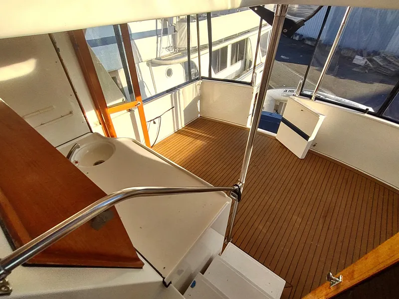 Slide: The Image of 1986 Nova 48 Cockpit Motor Yacht interior with wooden flooring and spacious seating area. - 23