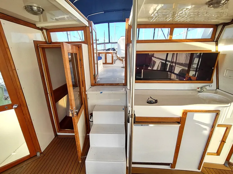 Slide: The Image of 1986 Nova 48 Cockpit Motor Yacht interior with wooden accents and stairs. - 24