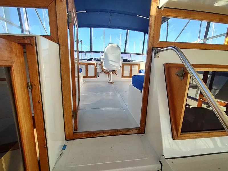 Slide: The Image of 1986 Nova 48 Cockpit Motor Yacht interior with helm, wooden accents, and blue upholstery. - 25
