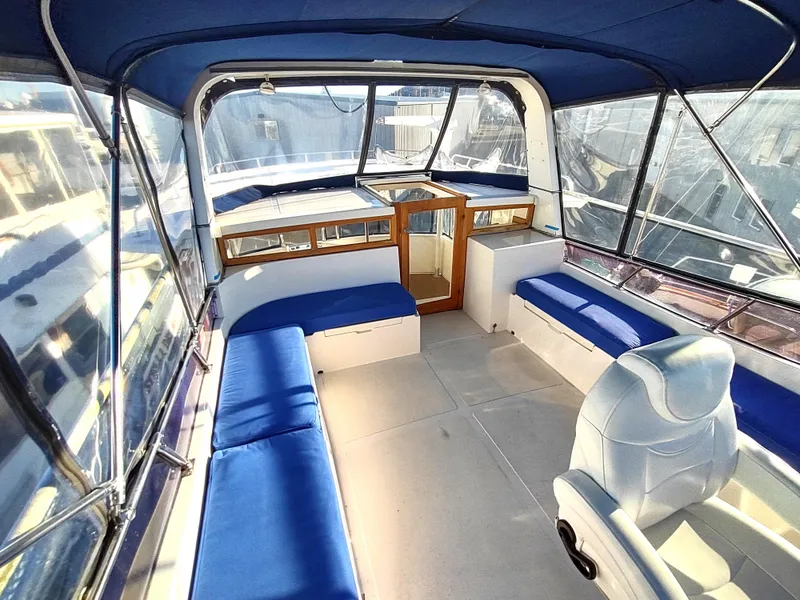 Slide: The Image of 1986 Nova 48 Cockpit Motor Yacht interior with blue seating and panoramic windows. - 27
