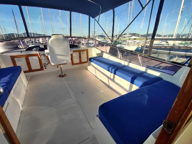 Slide: The Image of 1986 Nova 48 Cockpit Motor Yacht interior with blue seating and helm chair. - 28