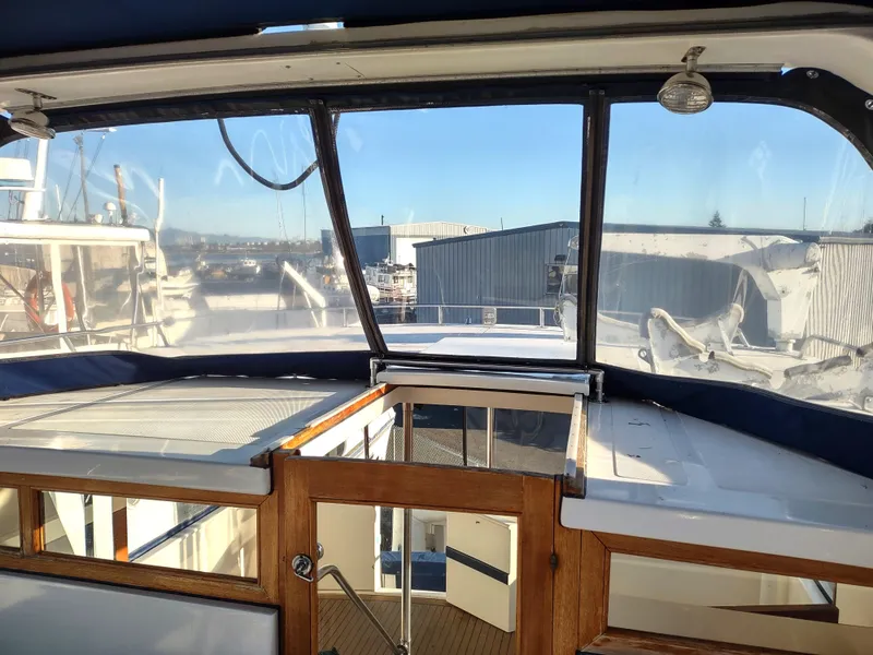 Slide: The Image of 1986 Nova 48 Cockpit Motor Yacht interior view with clear windows and wooden accents. - 29