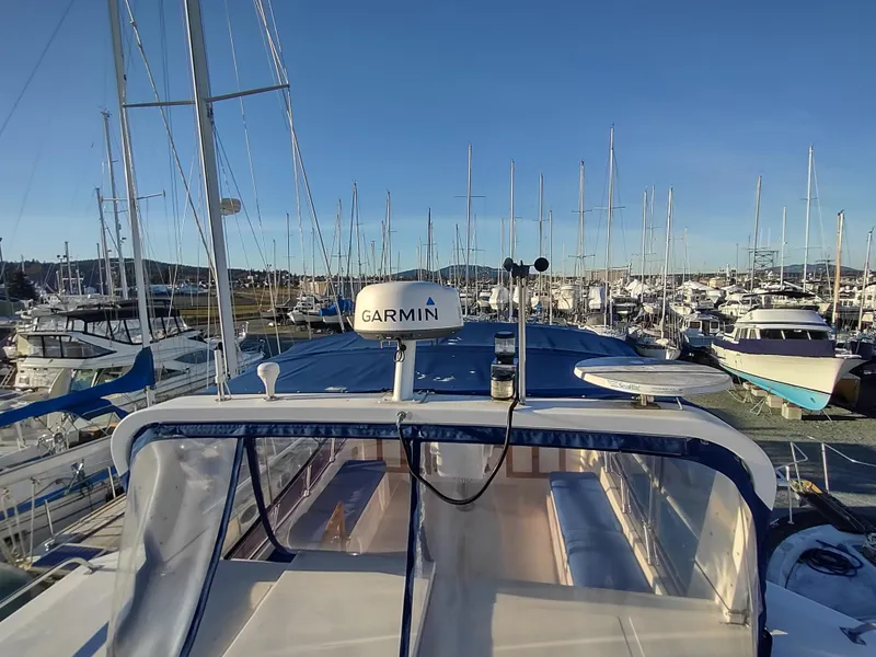 Slide: The Image of 1986 Nova 48 Cockpit Motor Yacht docked in a marina, surrounded by sailboats. - 30