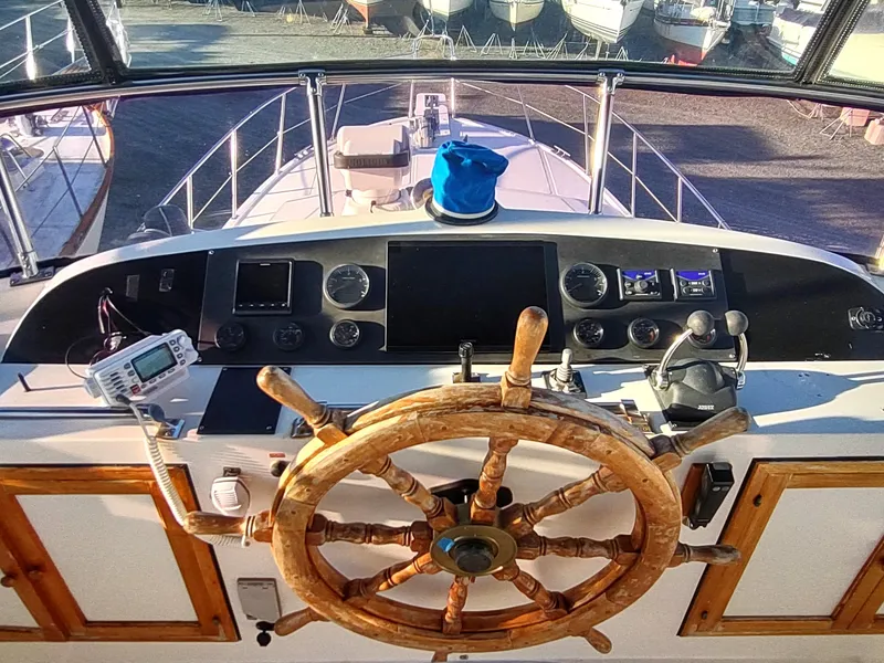 Slide: The Image of 1986 Nova 48 Cockpit Motor Yacht helm with wooden wheel and navigation instruments. - 31