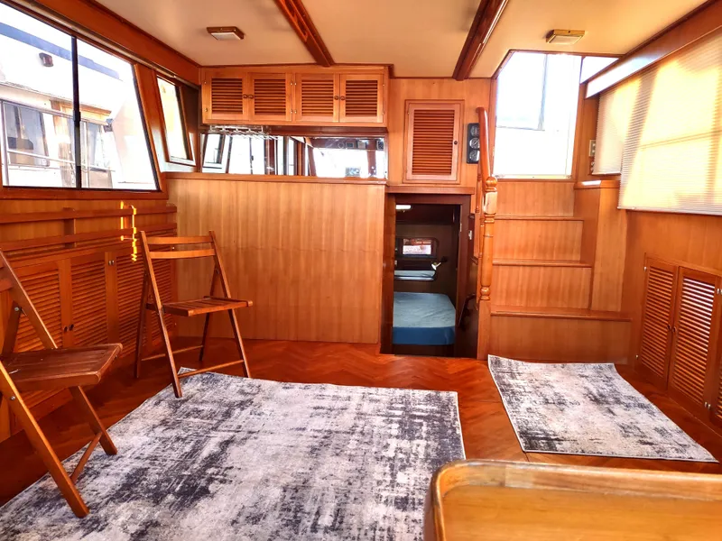 Slide: The Image of 1986 Nova 48 Cockpit Motor Yacht interior with wooden paneling and seating area. - 44