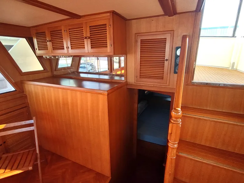 Slide: The Image of 1986 Nova 48 Cockpit Motor Yacht interior with wooden cabinetry and stairs. - 45