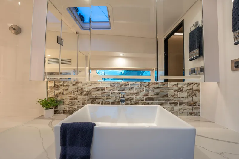 Slide: The Image of Luxurious bathroom in 2020 Horizon PC60 yacht with modern sink and skylight. - 25