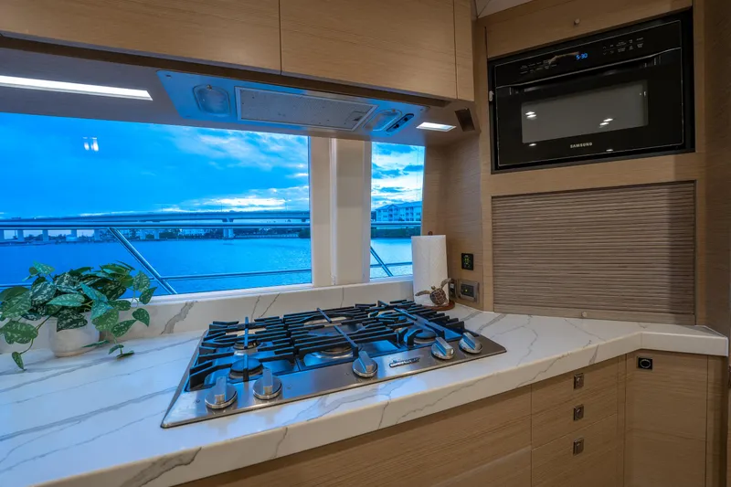 Slide: The Image of Modern yacht kitchen with stove, oven, and ocean view. Horizon PC60, 2020 model. - 7