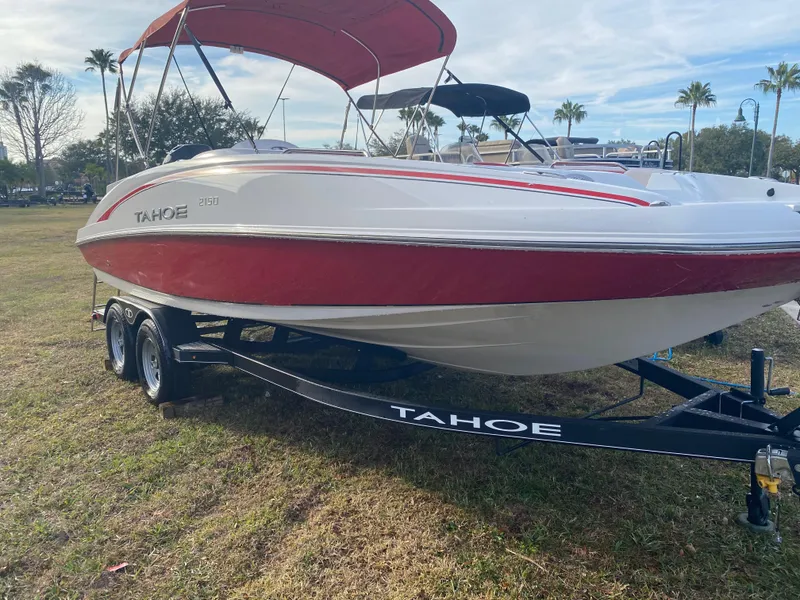 Slide: The Image of 2022 Tahoe 2150 boat with red and white design on a trailer, parked on grass. - 4