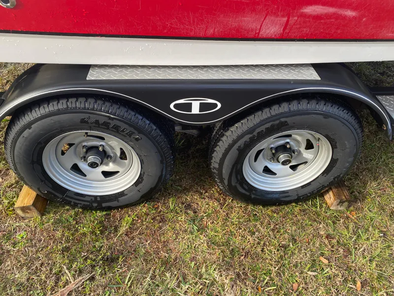 Slide: The Image of 2022 Tahoe 2150 trailer wheels on grass, featuring dual tires and wooden blocks. - 6