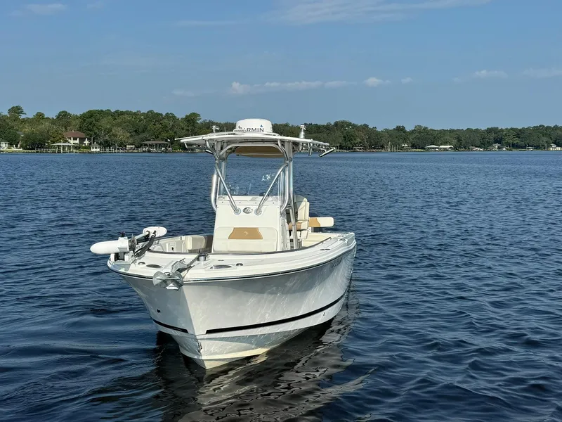 Slide: The Image of 2018 Edgewater 245CC boat on calm lake waters under clear sky. - 13