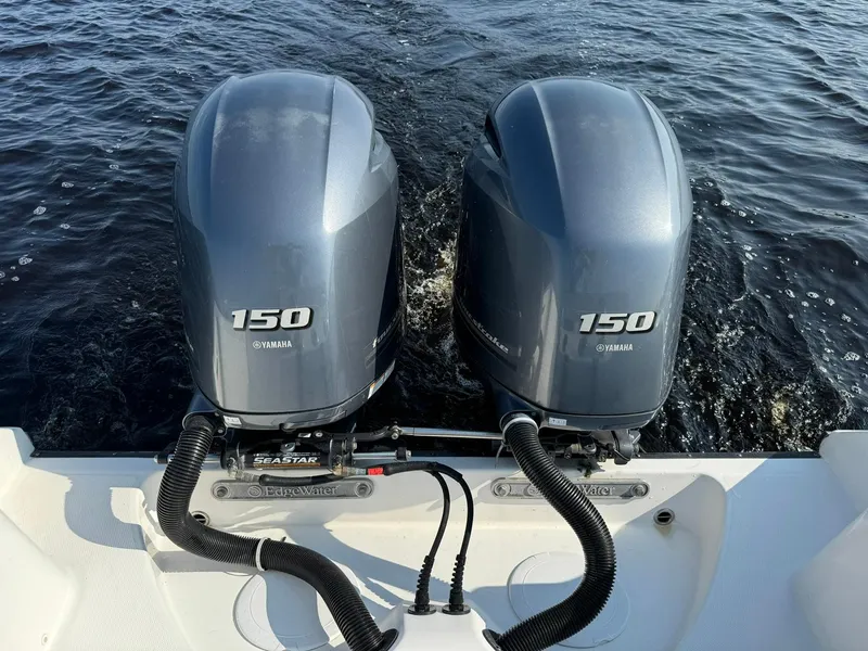 Slide: The Image of Twin Yamaha 150 engines on a 2018 Edgewater 245CC boat, cruising on water. - 20