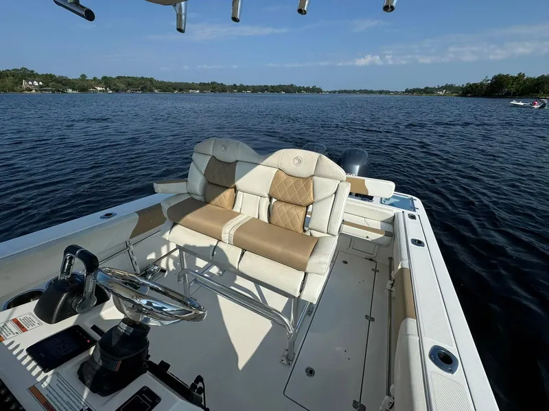 Slide: The Image of 2018 Edgewater 245CC boat interior with dual seats on a calm lake. - 26
