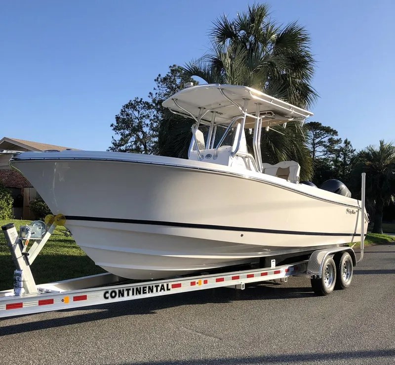 Slide: The Image of 2018 Edgewater 245CC boat on trailer, parked near palm trees. - 35
