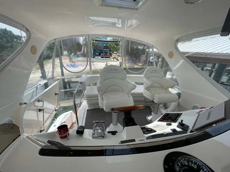 Slide: The Image of Interior view of 2003 Sea Ray 560 Sedan Bridge yacht cockpit with white seating. - 12