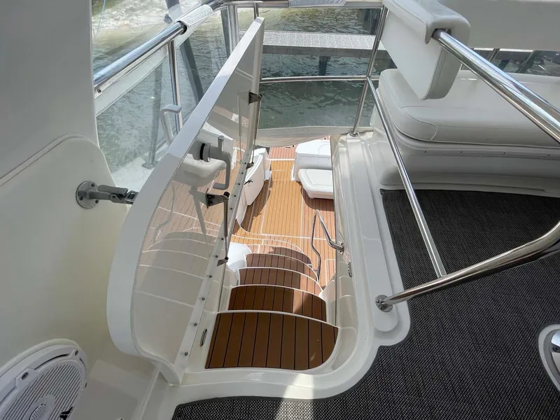 Slide: The Image of Staircase on 2003 Sea Ray 560 Sedan Bridge yacht with teak flooring and white seating. - 16