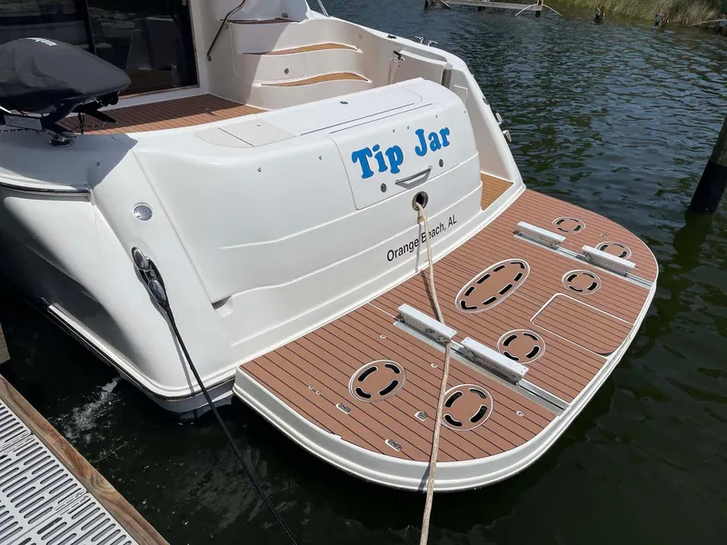Slide: The Image of 2003 Sea Ray 560 Sedan Bridge yacht docked, featuring "Tip Jar" name and wooden deck. - 18