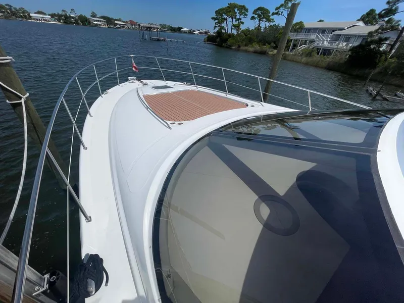 Slide: The Image of 2003 Sea Ray 560 Sedan Bridge yacht on calm waters, showcasing sleek design and spacious deck. - 19