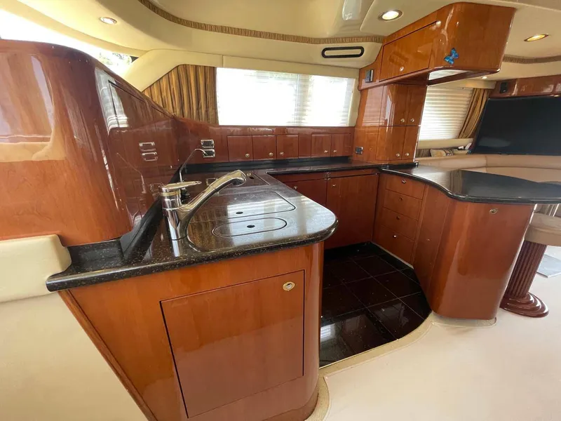 Slide: The Image of Luxurious kitchen interior of 2003 Sea Ray 560 Sedan Bridge yacht with wood cabinetry. - 25