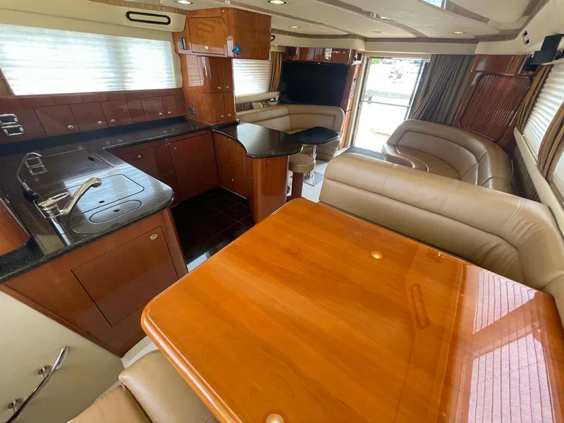 Slide: The Image of Luxurious interior of 2003 Sea Ray 560 Sedan Bridge yacht with modern kitchen and seating. - 28
