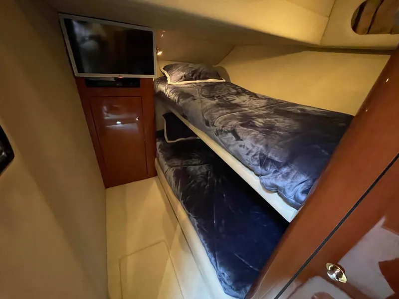 Slide: The Image of 2003 Sea Ray 560 Sedan Bridge cabin with bunk beds and TV. - 31