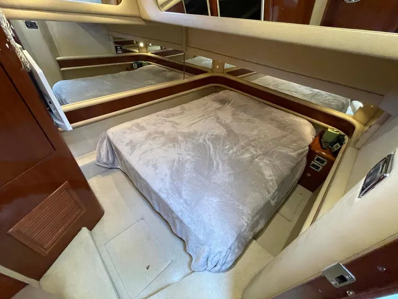 Slide: The Image of Interior cabin of 2003 Sea Ray 560 Sedan Bridge yacht with bed and mirrored walls. - 32
