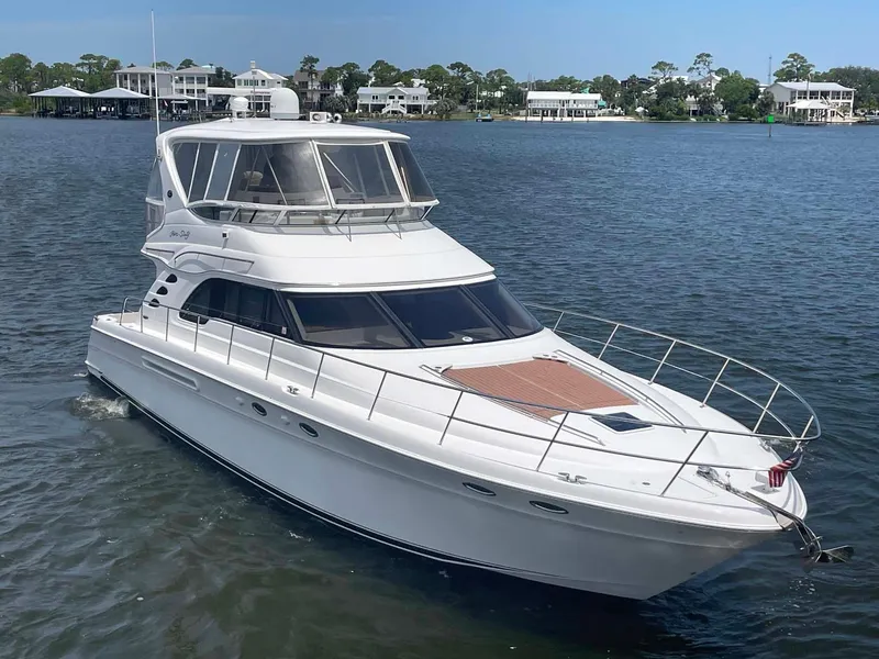 Slide: The Image of 2003 Sea Ray 560 Sedan Bridge yacht cruising on a calm lake. - 4