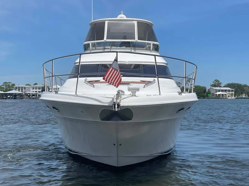 Slide: The Image of 2003 Sea Ray 560 Sedan Bridge yacht on water, front view with American flag. - 6