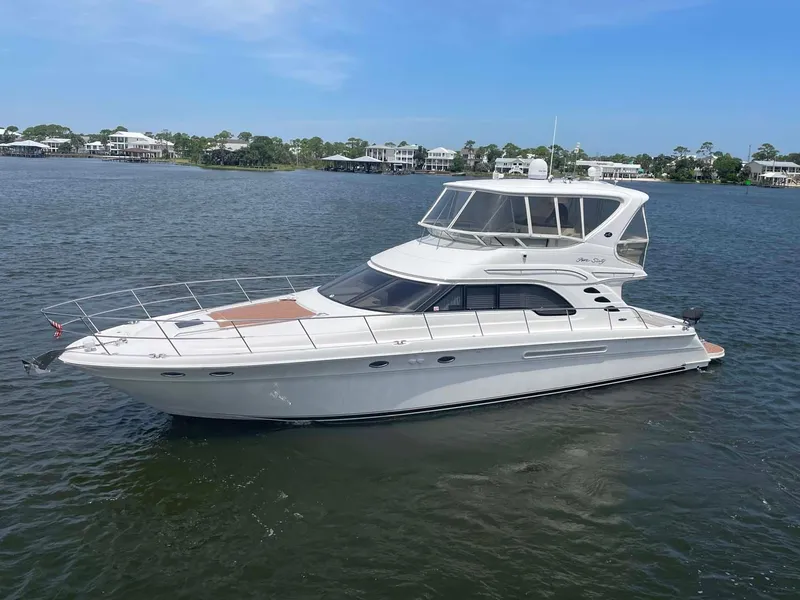 Slide: The Image of 2003 Sea Ray 560 Sedan Bridge yacht on calm water, clear sky background. - 7