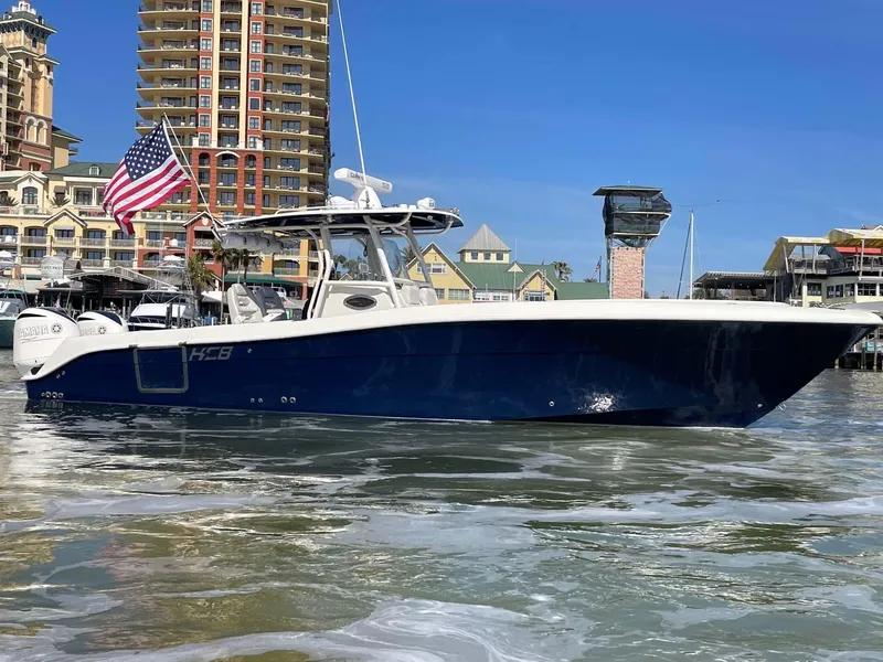 Slide: The Image of 2015 Hydra-Sports 3400 Center Console boat on water, cityscape background, American flag displayed. - 34