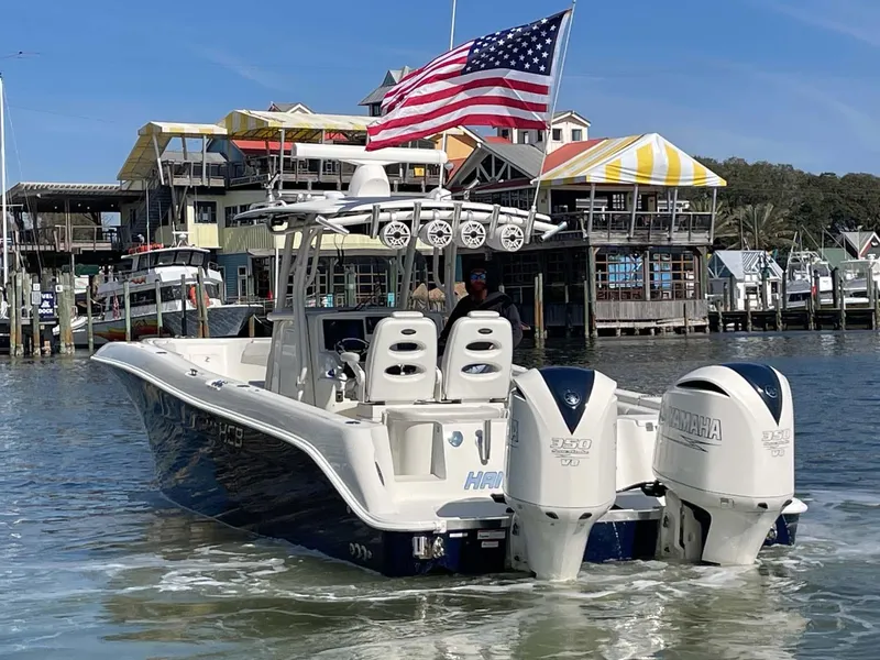 Slide: The Image of 2015 Hydra-Sports 3400 Center Console boat with dual Yamaha engines, docked near colorful waterfront buildings. - 38