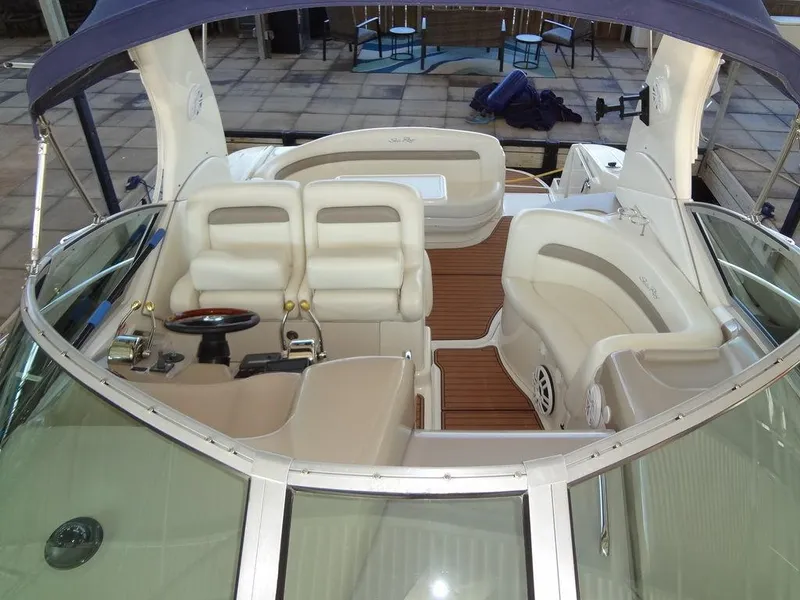 Slide: The Image of 2005 Sea Ray 320 Sundancer boat interior with white seating and wooden flooring. - 24