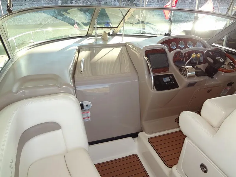 Slide: The Image of 2005 Sea Ray 320 Sundancer cockpit with beige seating and wood accents. - 26