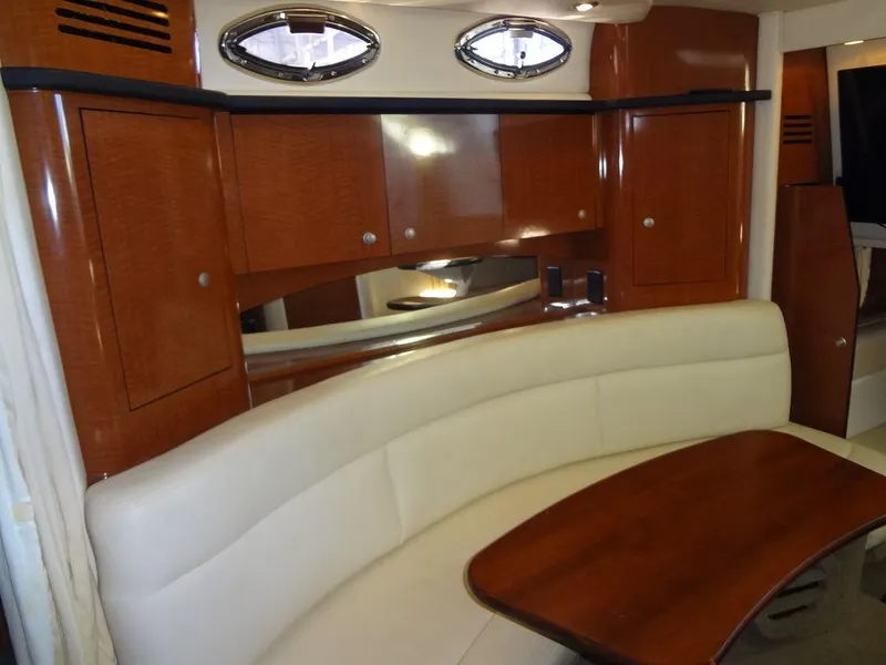 Slide: The Image of 2005 Sea Ray 320 Sundancer interior with wood cabinetry and curved seating. - 27