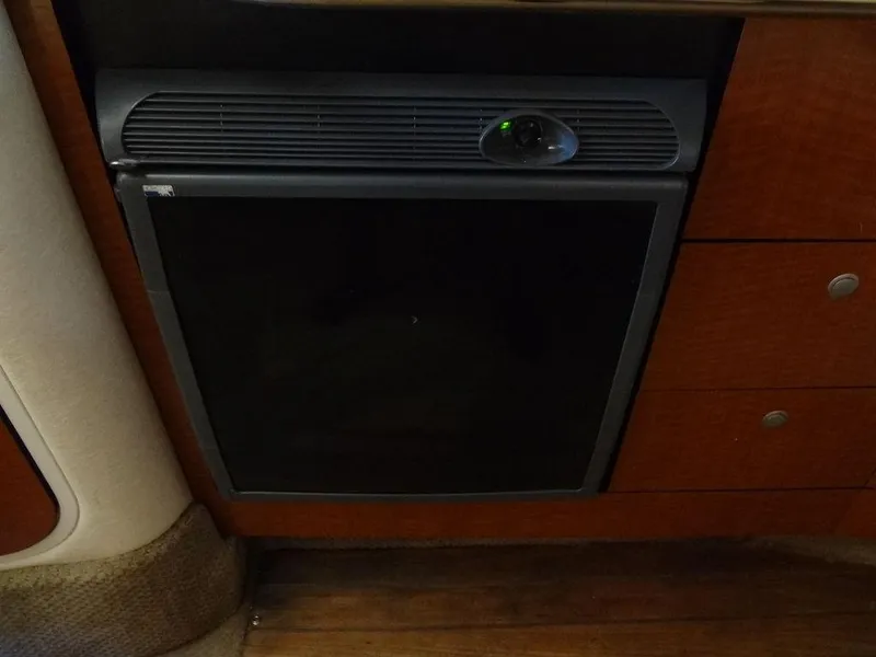 Slide: The Image of 2005 Sea Ray 320 Sundancer interior with a compact refrigerator. - 33