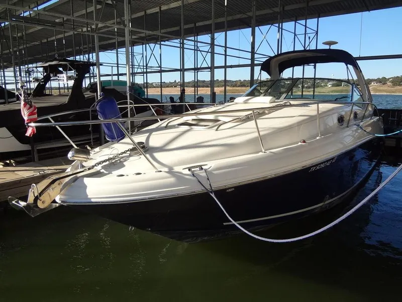 Slide: The Image of 2005 Sea Ray 320 Sundancer docked in a marina, under a covered structure. - 4