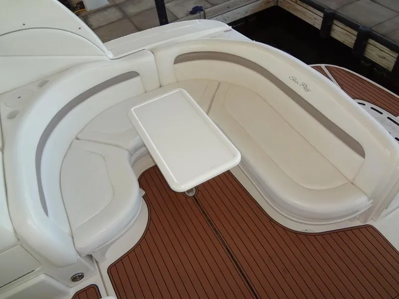 Slide: The Image of 2005 Sea Ray 320 Sundancer seating area with table, featuring white upholstery and wood flooring. - 6