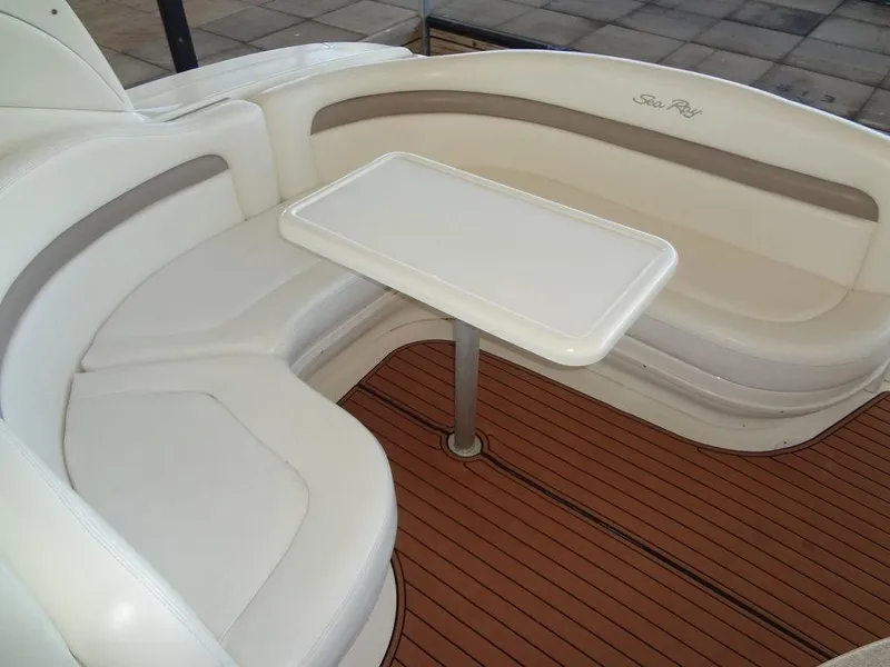 Slide: The Image of 2005 Sea Ray 320 Sundancer interior with white seating and table on teak flooring. - 8