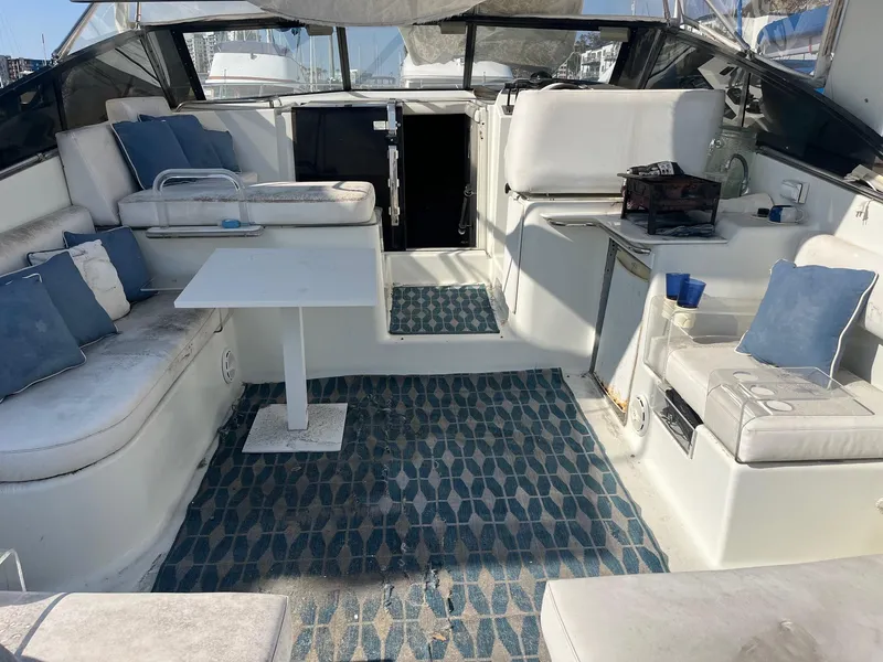 Slide: The Image of 1993 Silverton 38 Express yacht interior with seating, table, and blue accents. - 12