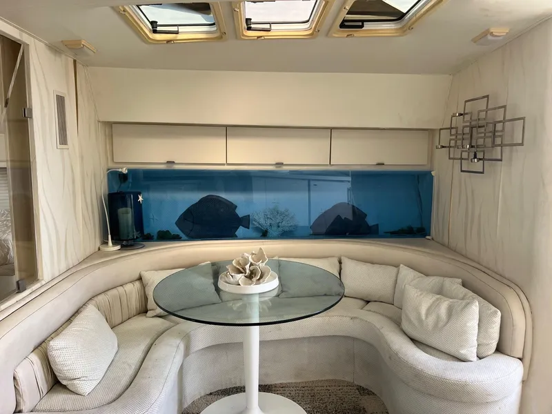 Slide: The Image of Interior of 1993 Silverton 38 Express yacht with curved seating and glass table. - 5