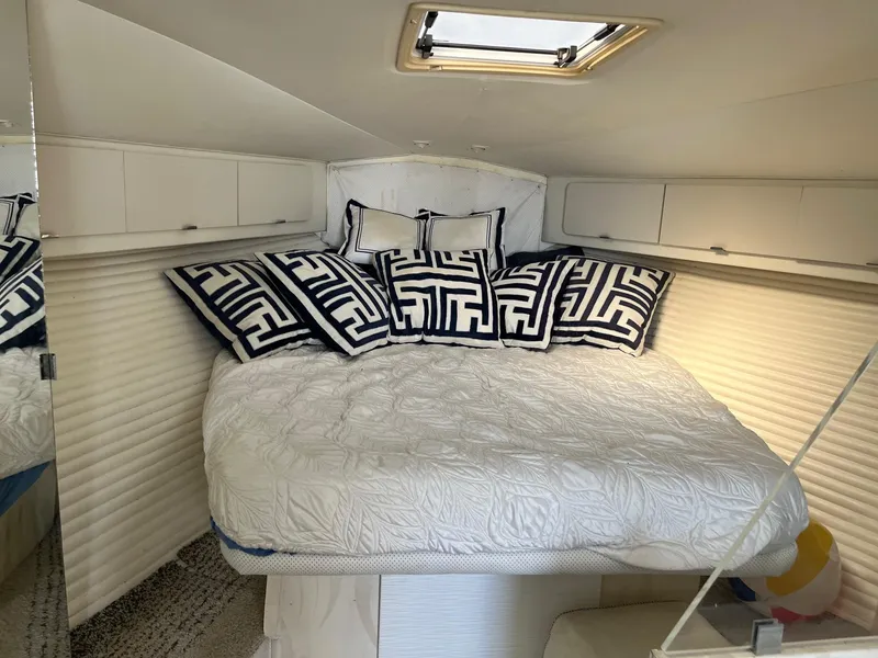Slide: The Image of Interior of 1993 Silverton 38 Express yacht with cozy bed and decorative pillows. - 6