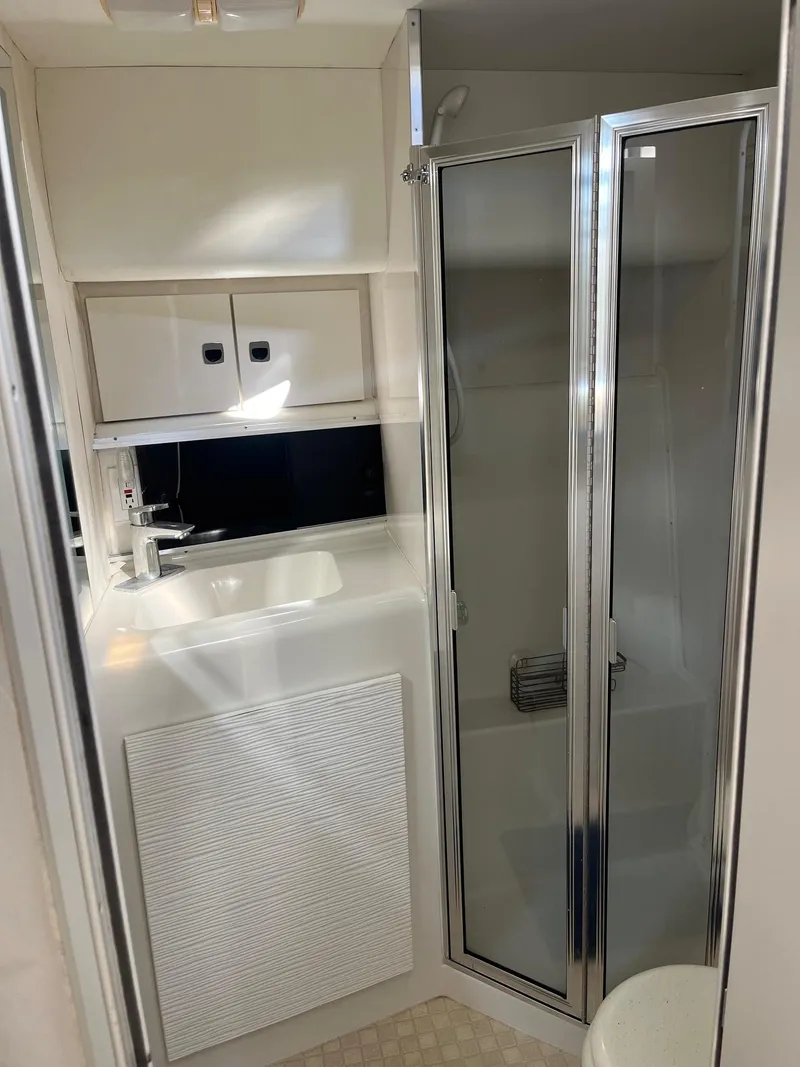 Slide: The Image of 1993 Silverton 38 Express yacht bathroom with shower, sink, and storage cabinets. - 8