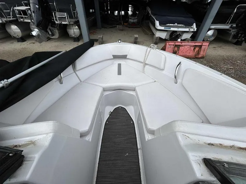 Slide: The Image of 2018 Four Winns Horizon 190 boat interior, white seating, docked in storage area. - 10